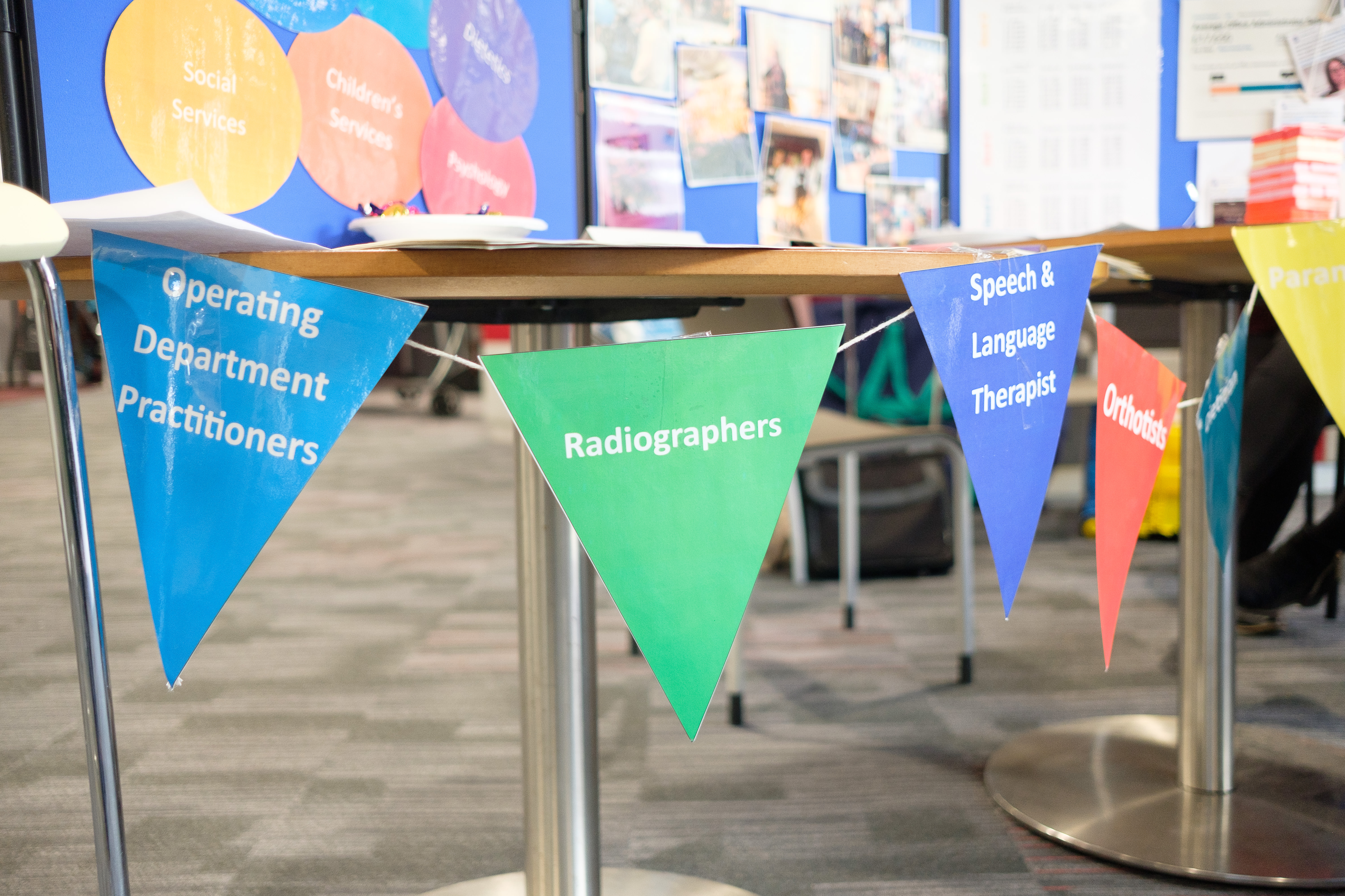 A table draped with bunting with the words operating department practitioners, radiographers, speech and language therapists and orthotists on