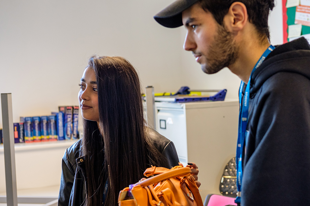 A young man and woman standing in an office