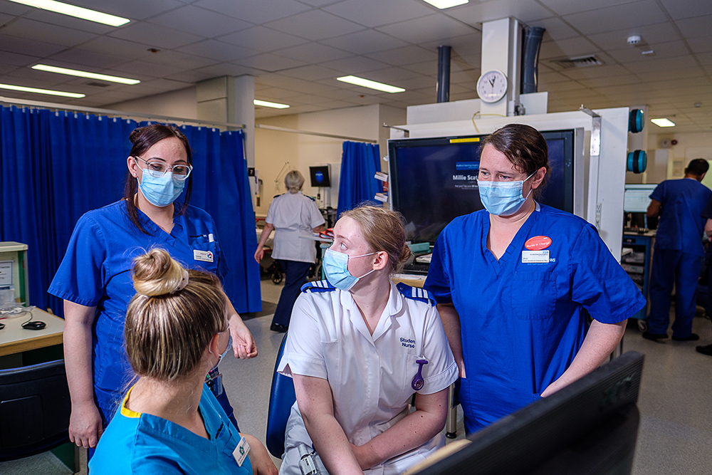 A group of three nurses and a student nurse on a hospital ward